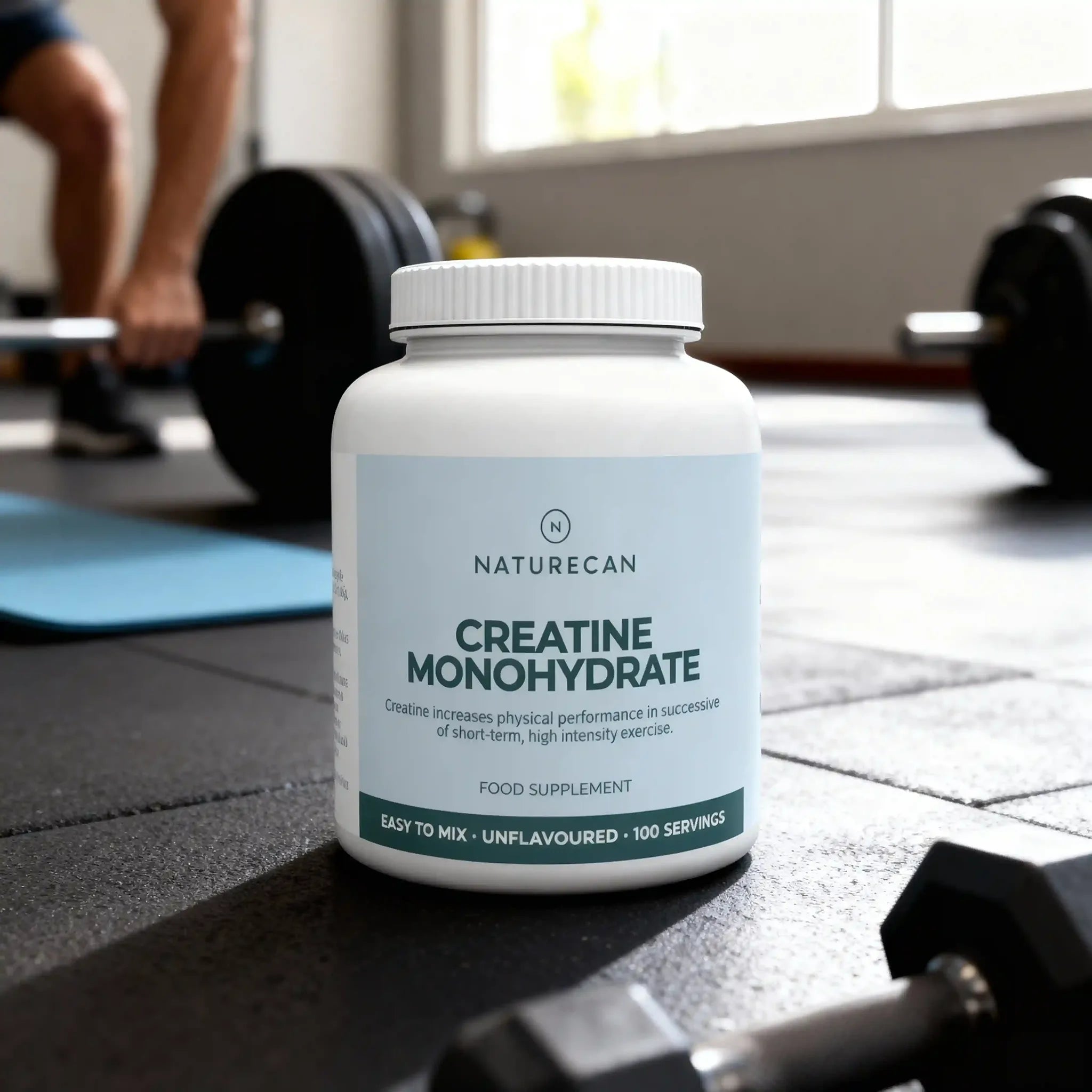 White Naturecan Creatine Monohydrate container on a gym floor, labeled as unflavoured with 100 servings.