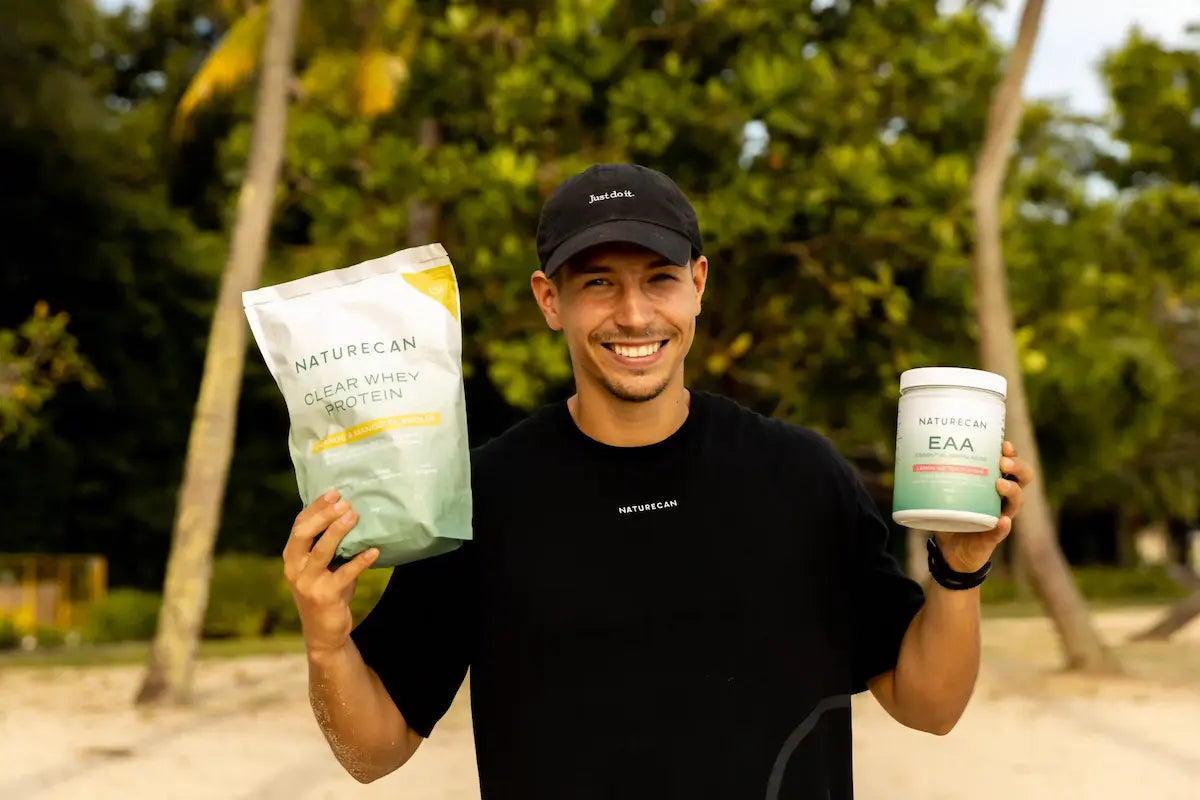 Man holding Naturecan products outdoors with trees in the background