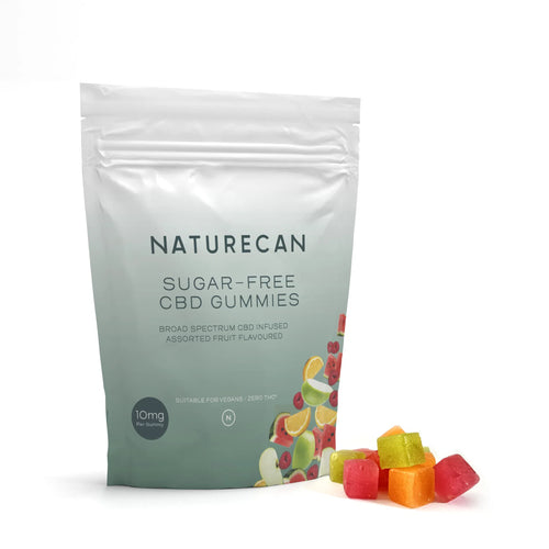 Packaged Sugar Free CBD Gummies with colorful fruit illustrations and loose gummies beside the bag.