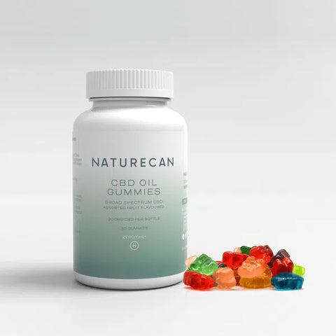 A bottle of CBD Oil Gummy Bears labeled "Naturecan" with colorful gummy bears beside it.