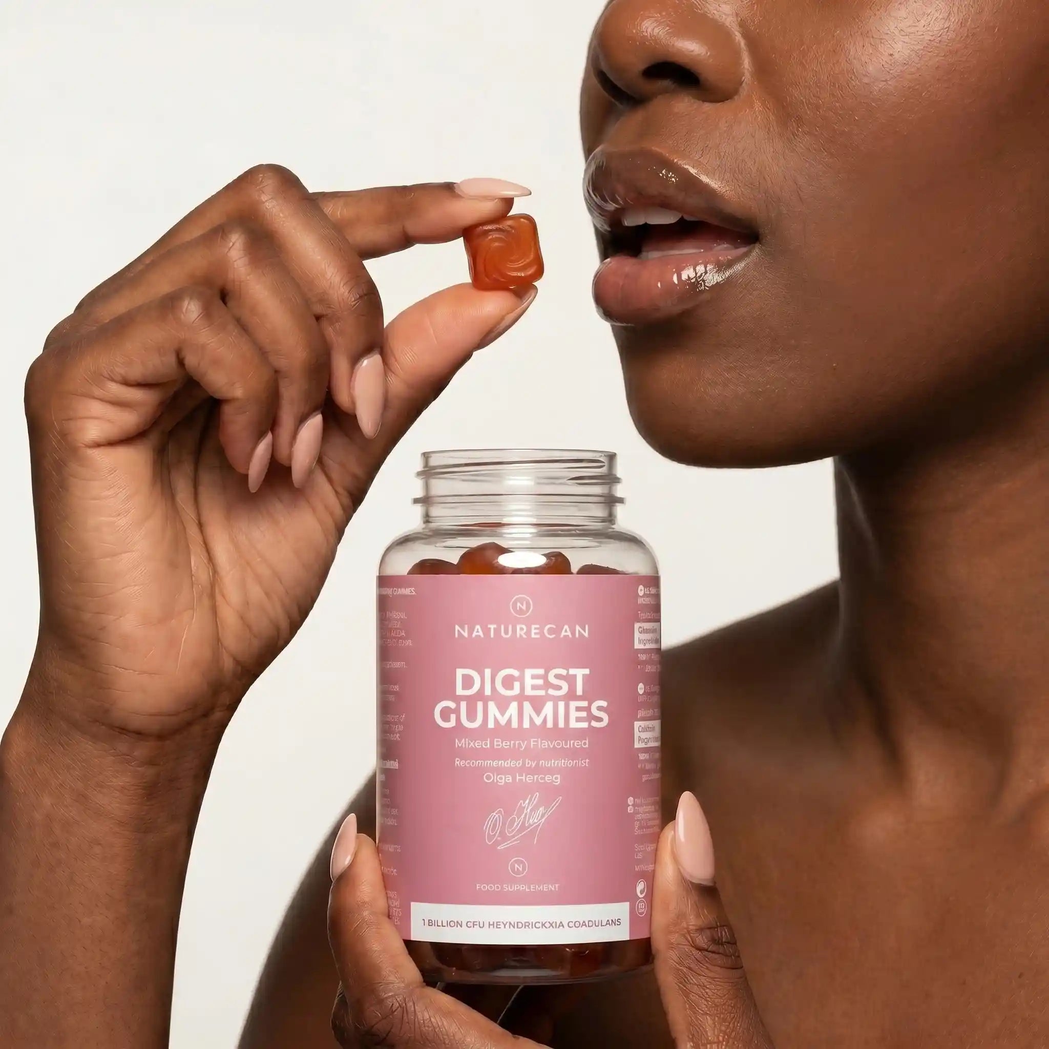 Person holding a bottle of Naturecan Digest Gummies with a neutral background