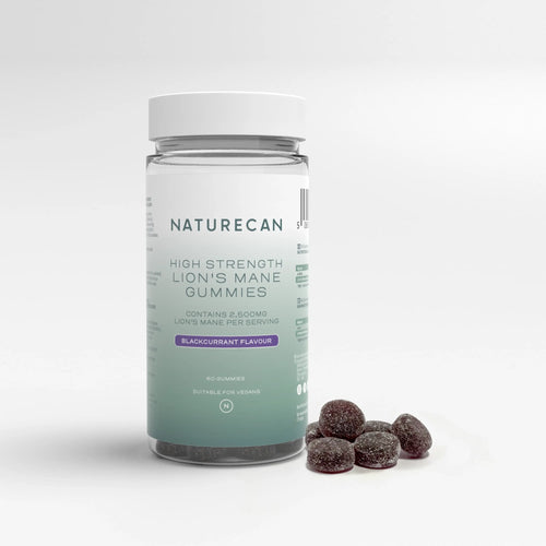 A jar of high strength Lion’s Mane Gummies with a white lid and blackcurrant flavor label, next to scattered gummies.