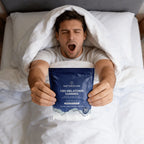 Man in bed holding a package of Naturecan CBD Melatonin Gummies