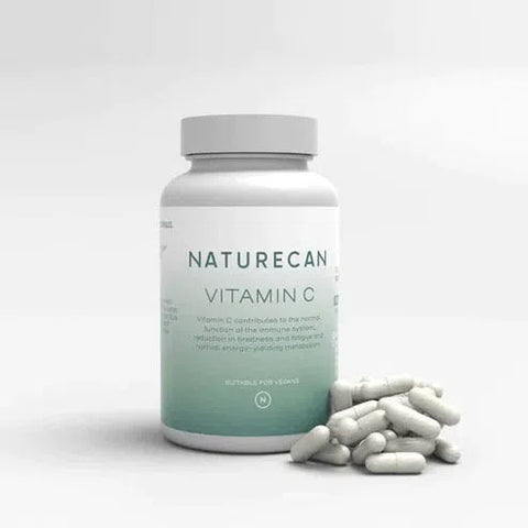 A bottle of Naturecan Vitamin C Capsules with some capsules scattered in front.