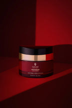 Cosmetic jar with black, red, and gold design on a red background